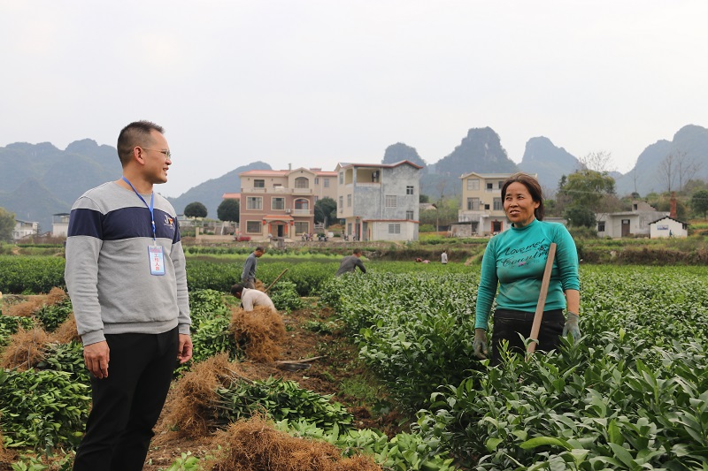 荔浦市马岭镇纪委书记陈振斌(左)在农户了解春耕春种方面存在的困难